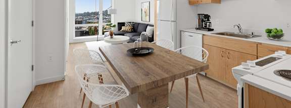 A kitchen with a table and chairs in front of a window.