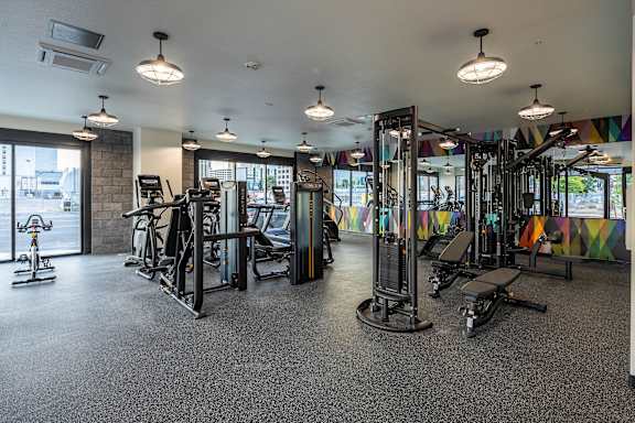 A gym with a variety of equipment including treadmills, weights, and exercise machines.