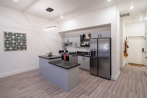 A modern kitchen with a large island and stainless steel appliances.