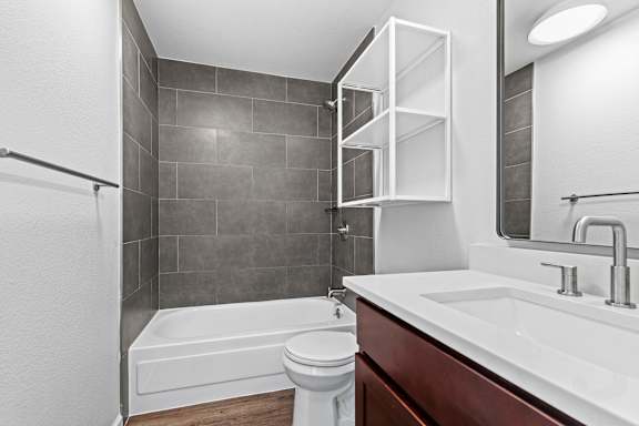 A white toilet sits next to a white sink in a modern bathroom.