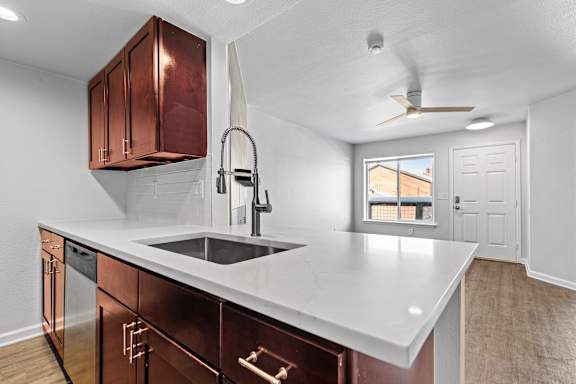 A kitchen with a white countertop and copper cabinets.
