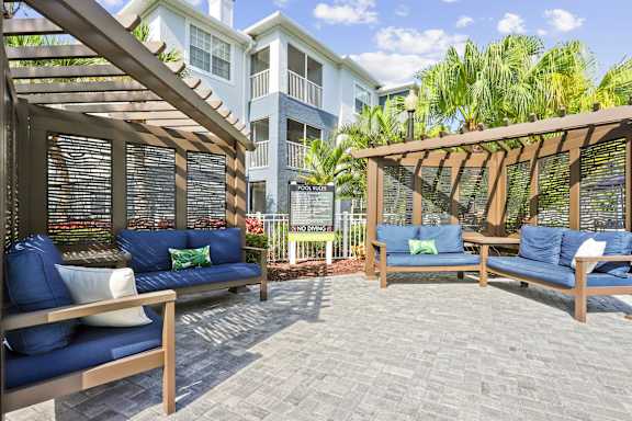 A patio with wooden furniture and a blue cushion.