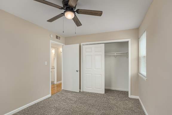 A room with a ceiling fan and a white door.