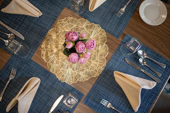 A table setting with a gold plate and pink flowers.