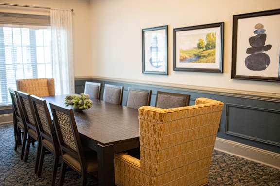 A conference room with a long table and chairs.