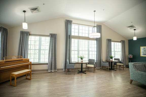 A room with a wooden bench and grey chairs.