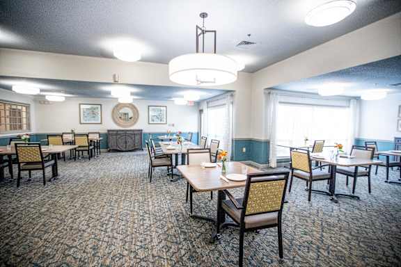 A dining room with tables and chairs and a chandelier.at Spring Arbor of Wilson, Wilson, NC