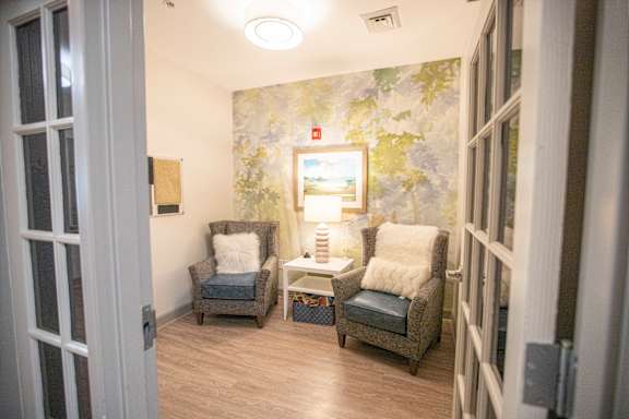 A room with two chairs and a table with a painting on the wall.at Spring Arbor of Wilson, Wilson, 27893-2873