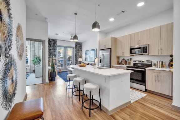 an open kitchen with a large white island and stools