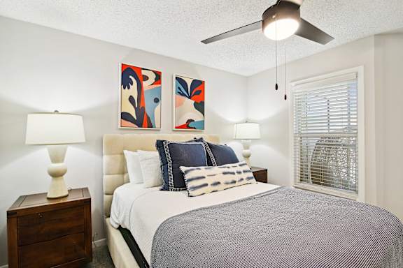 a bedroom with a bed and a ceiling fan