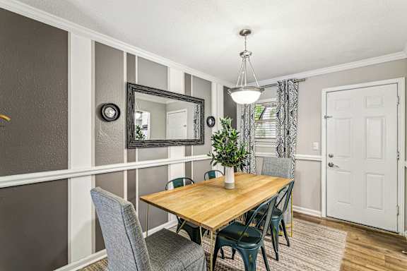 A dining room with a wooden table and grey chairs.