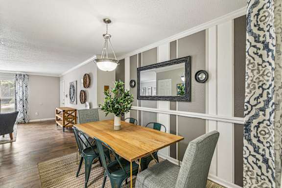 A dining room with a wooden table and chairs.