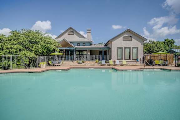 A house with a pool in front of it.
