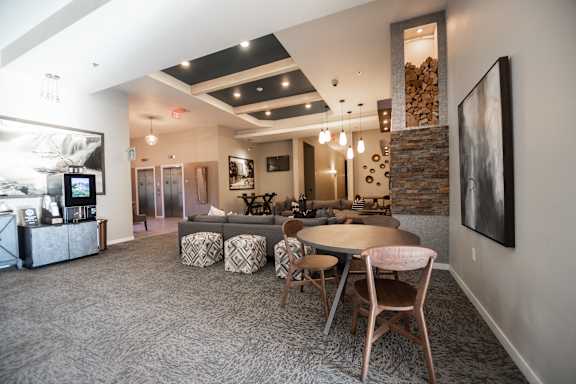 A modern living room with a stone fireplace and a large painting on the wall.