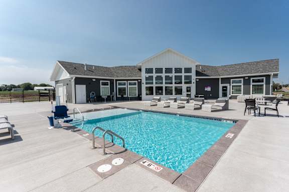 A large swimming pool with a building in the background.