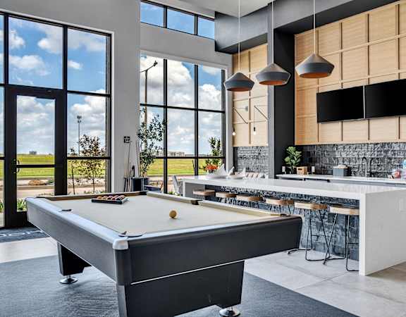 a clubhouse with a pool table and a kitchen with a bar