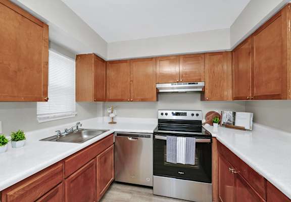 a kitchen with wooden cabinets and stainless steel appliances