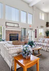 A living room with a couch, a chair, a coffee table, and a fireplace.