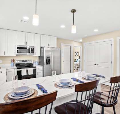 a kitchen and dining area with a white counter top and white cabinets