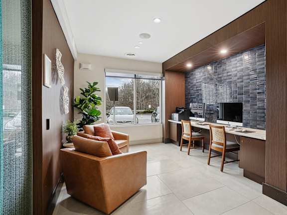 A modern living room with a brown couch and a stone wall.