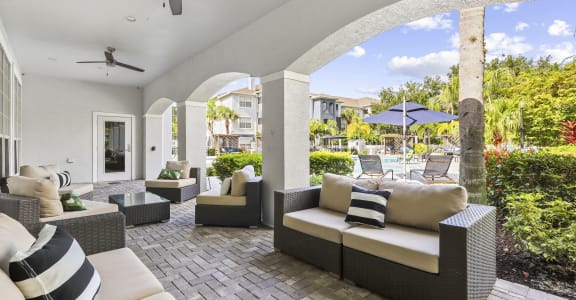 an outdoor patio with couches and chairs and umbrellas