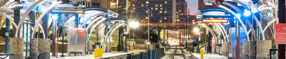 a city at night with train tracks and buildings in the background