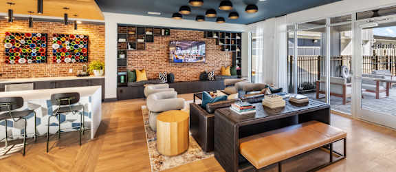 A modern living room with a brick wall and a flat screen TV.