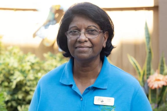 a woman in a blue shirt and glasses smiling