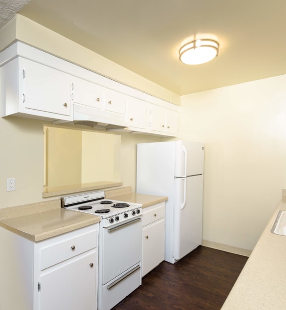 a kitchen with white appliances and white cabinets