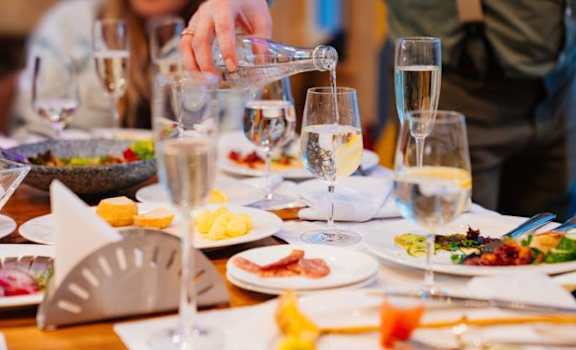 a person pouring wine into a table full of plates of food at Lumina at Spanish Springs, Sparks, Nevada