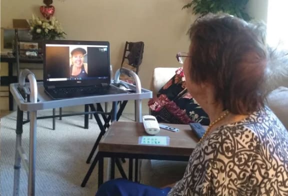 senior resident watching a video on a laptop at Savannah Grand of Sarasota, Sarasota, FL