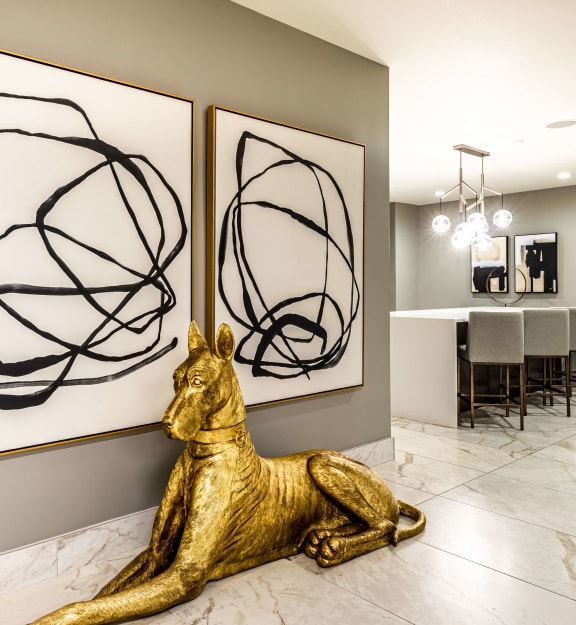 a room with two paintings and a statue of a dog  at The Grand, Kansas City