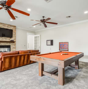 a living room with a pool table and a fireplace
