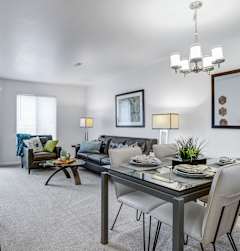 A modern dining room with a glass table and chairs.