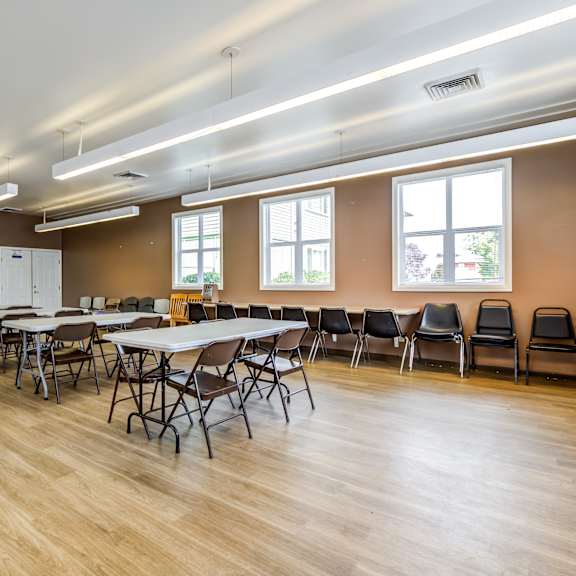 A large room with tables and chairs and a kitchen area.at Lake Washington Apartments, Washington