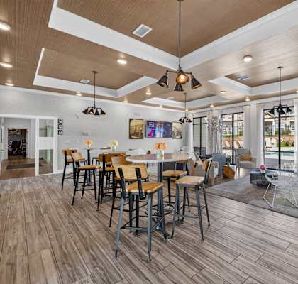 A modern dining room with wooden floors and a large TV mounted on the wall.