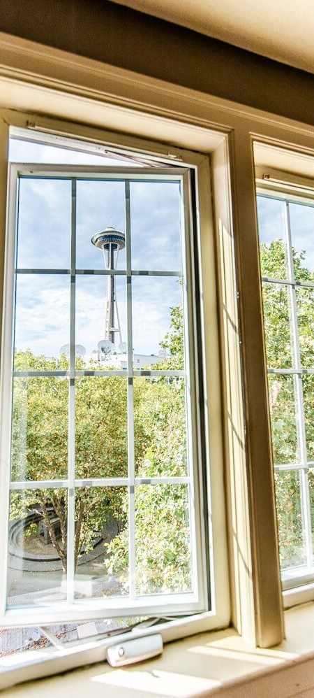 A window with a view of a balcony and trees.