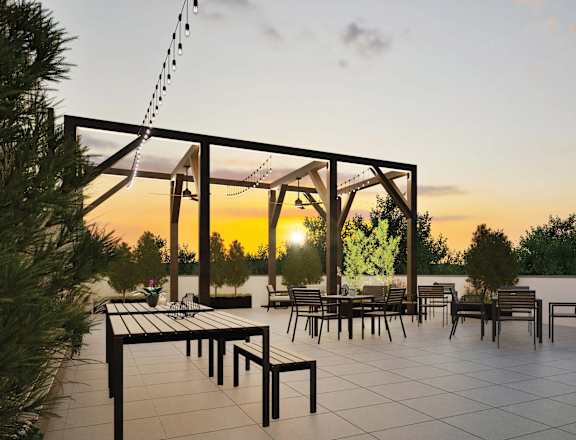 A sunset view of a patio with tables and chairs.