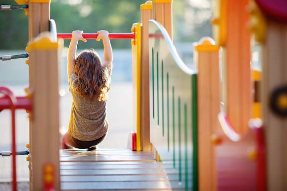 A child is playing on a playground slide.