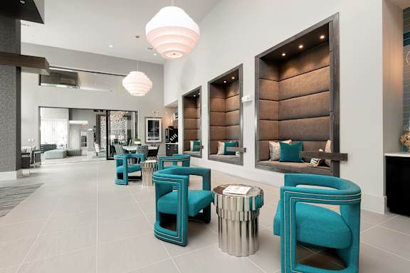A room with blue chairs and a fireplace.