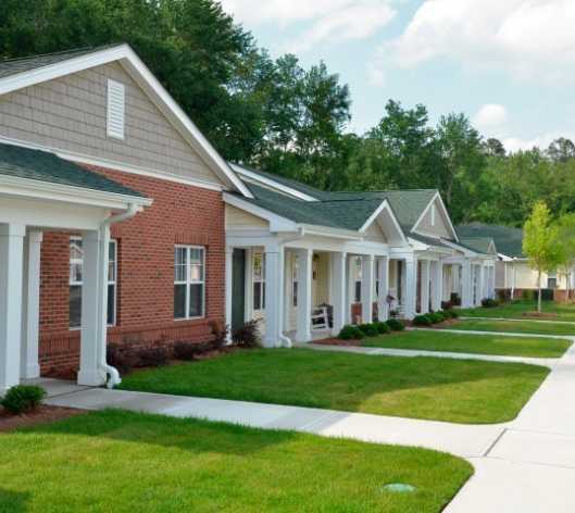 a row of houses with white pillars and green grass