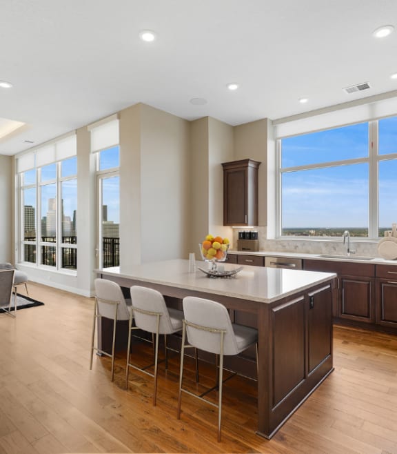 a large kitchen with a large island with white chairs