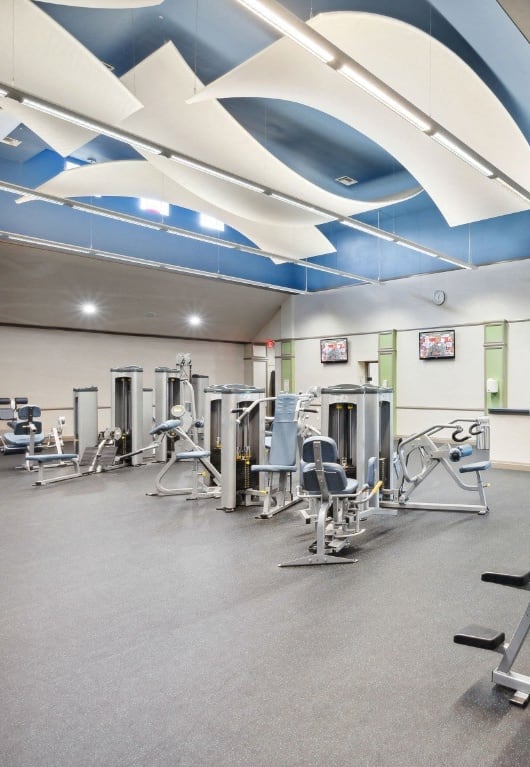 a large fitness center with exercise equipment and green walls at Via Lugano, Boynton Beach, FL, 33436