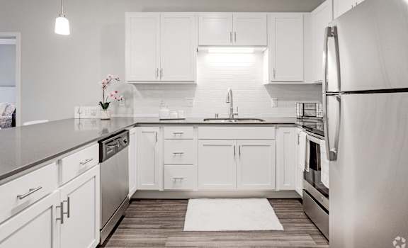 a white kitchen with white cabinets and stainless steel appliances