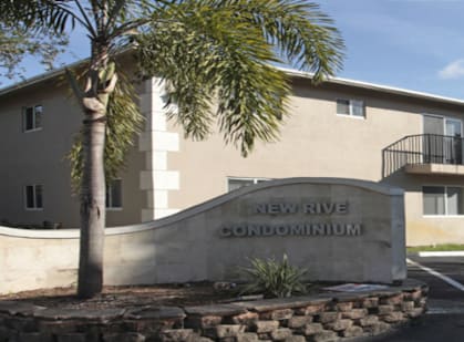 a building with a sign for the new river condominiums