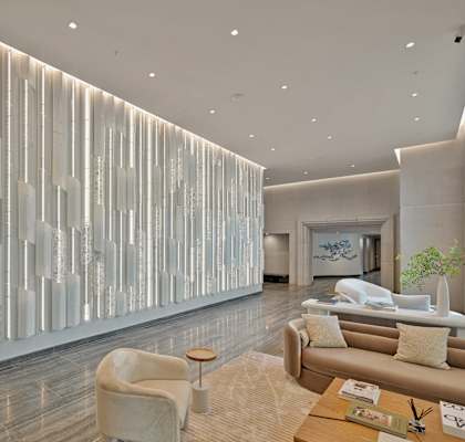 a lobby with a fireplace and a glass wall with cascading lights at Riello Apartments Owner LLC, NJ, 07020