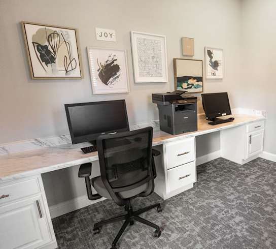 A room with a desk, chair, and computer.
