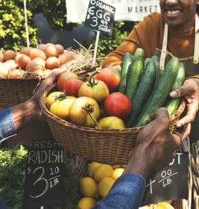 people holding baskets of fruit and vegetables at a market