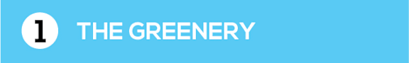 A blue sign with a white circle and the words "THE GREENERY" written in white.