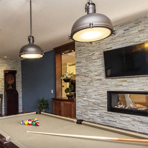 a pool table in a living room with a fireplace